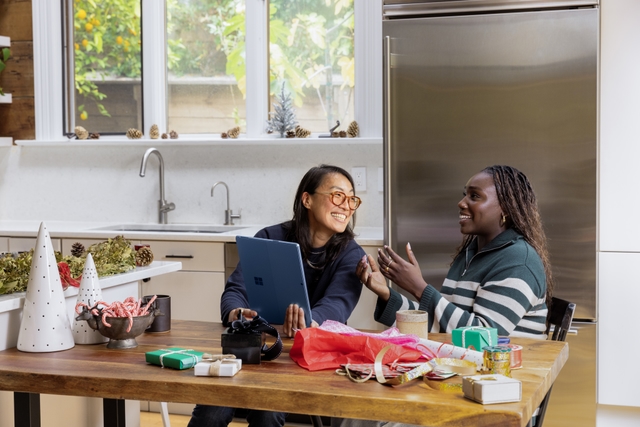 Two girls laughing in a kitchen