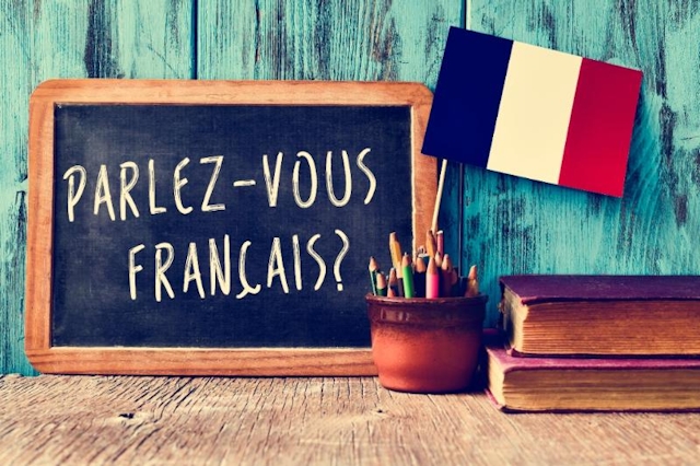 A French flag and a chalkboard with "parlez-vous français" written on it